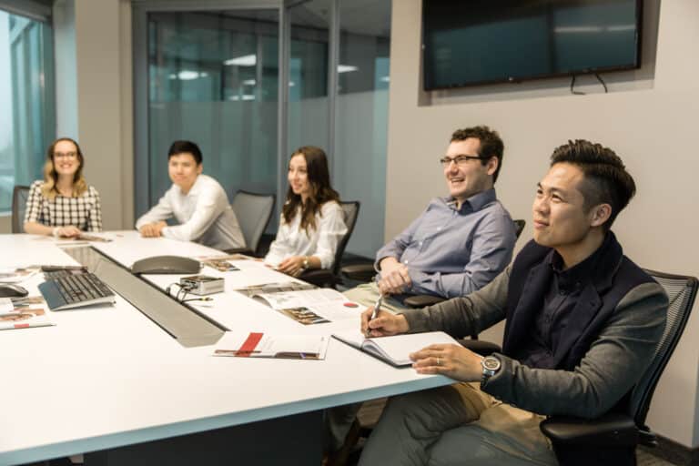 A group of people smiling during a meeting
