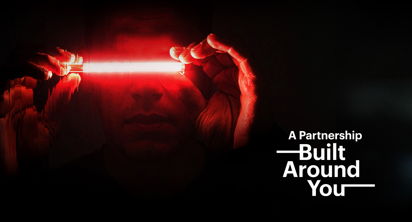 Promotional banner with a red laser beam and the slogan 'A Partnership Built Around You'.